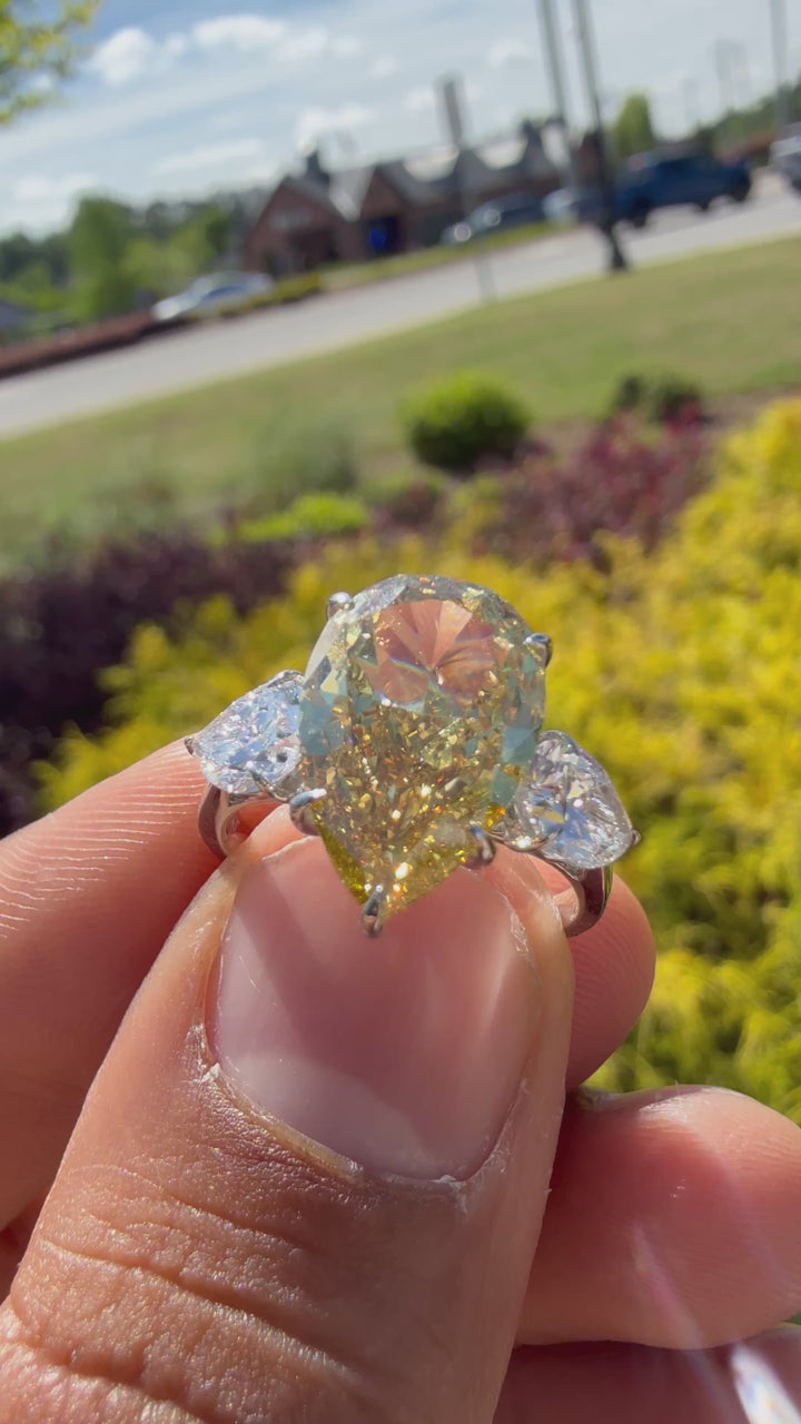 6.5  carat ring with fancy vivid yellow igi certified stone ehandcrafted in color high cut with fancy 2 pear on side stone in  ring handcrafted ring made with 14k gold in grown diamond igi certified
